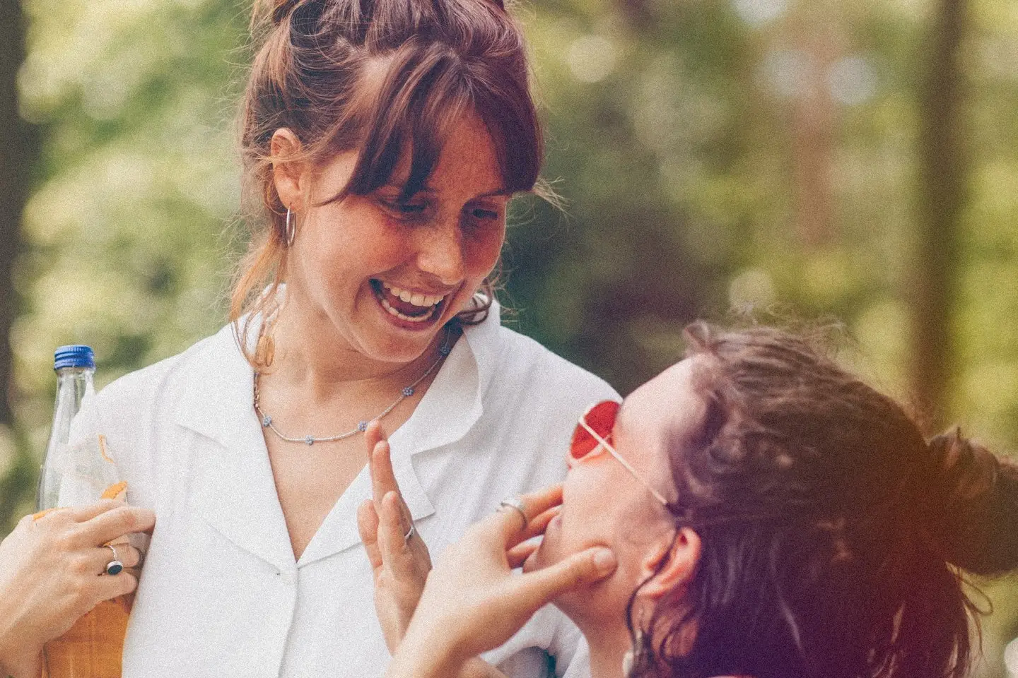 Zwei Frauen lachen gemeinsam im Wald