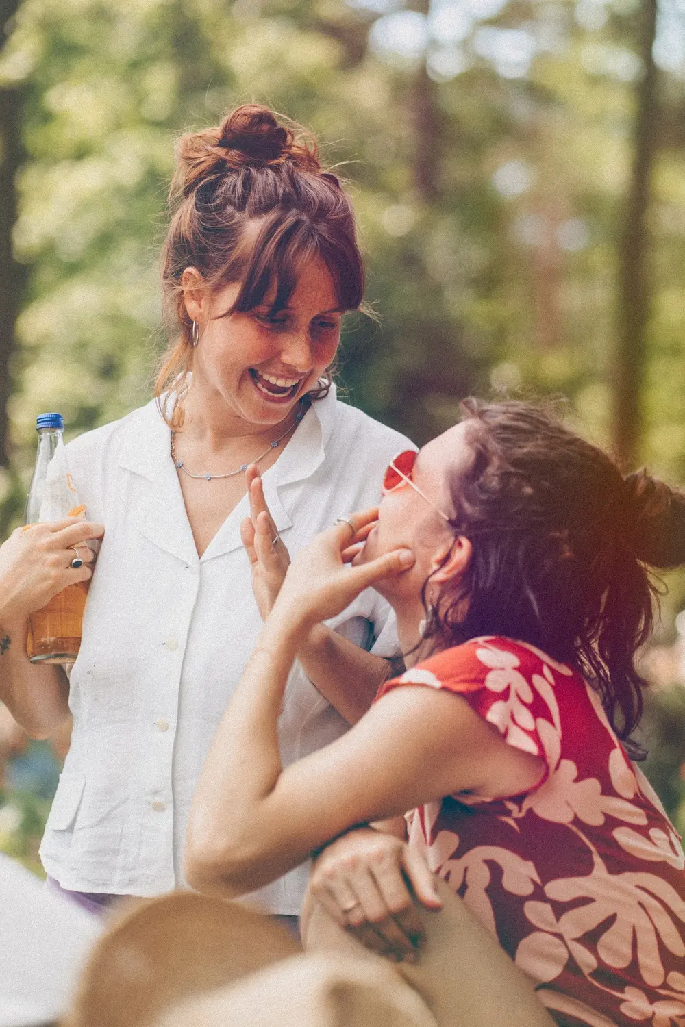 Zwei Frauen lachen gemeinsam draußen im Wald